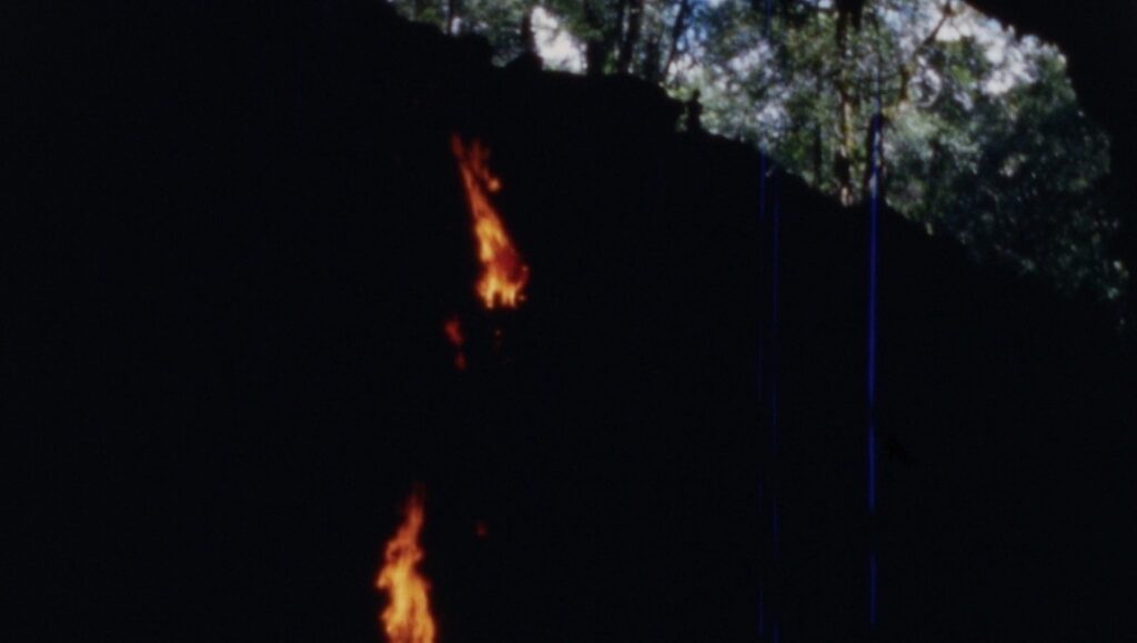 Ernst Karel & Veronika Kusumaryati's Expedition Content film still. Fire in a dark forest.