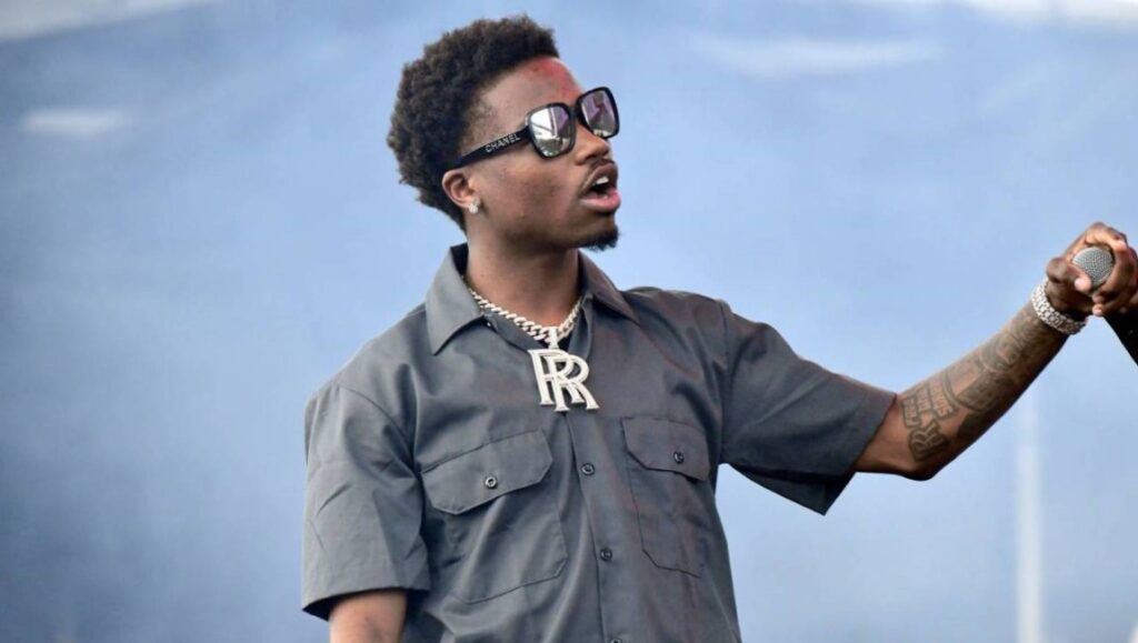 Roddy Ricch — Live Life Fast Roddy Ricch performing live. The rapper wears sunglasses and a large R pendant necklace. Live Life Fast artist.