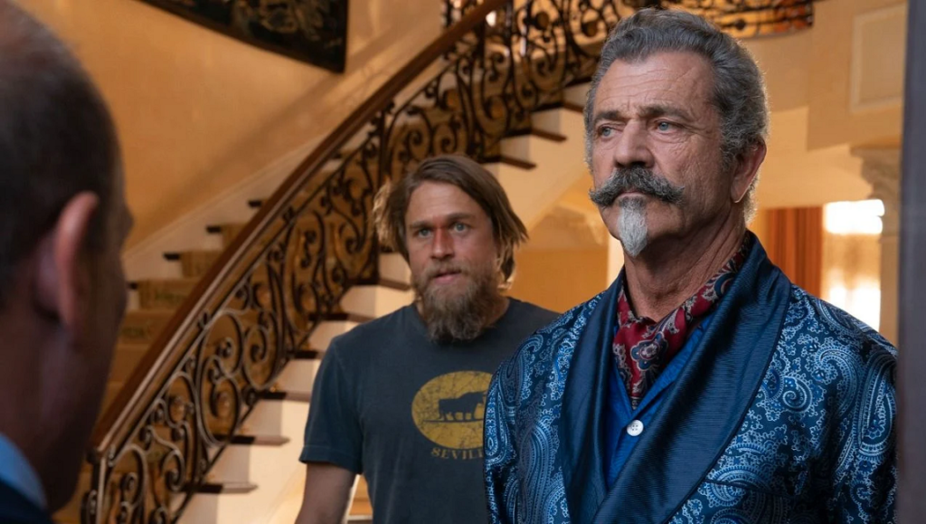 Last Looks movie still: Mel Gibson in a paisley robe with Charlie Hunnam in the background.