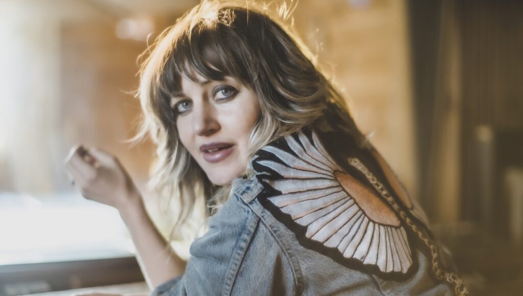 Anaïs Mitchell, January 2022 album roundup. Singer-songwriter with butterfly denim jacket.
