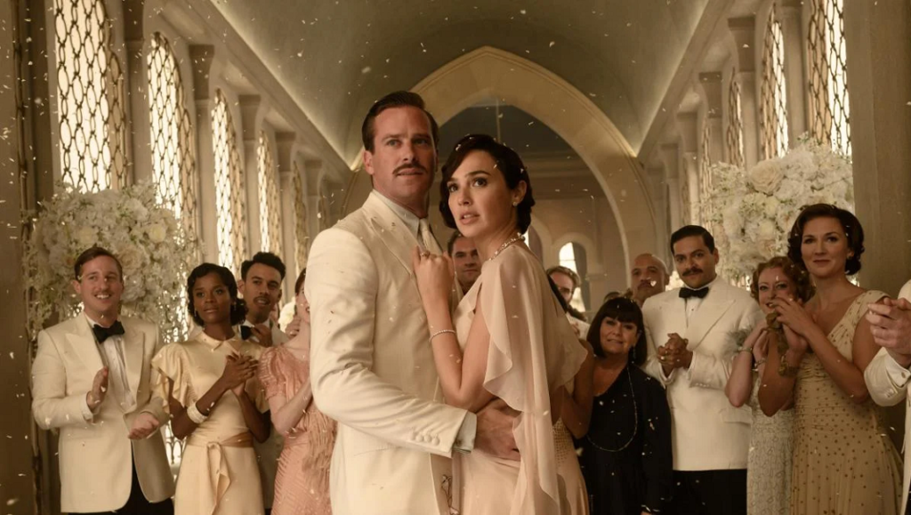 Death on the Nile — Kenneth Branagh Death on the Nile movie scene: Gal Gadot and Armie Hammer at their wedding with guests.