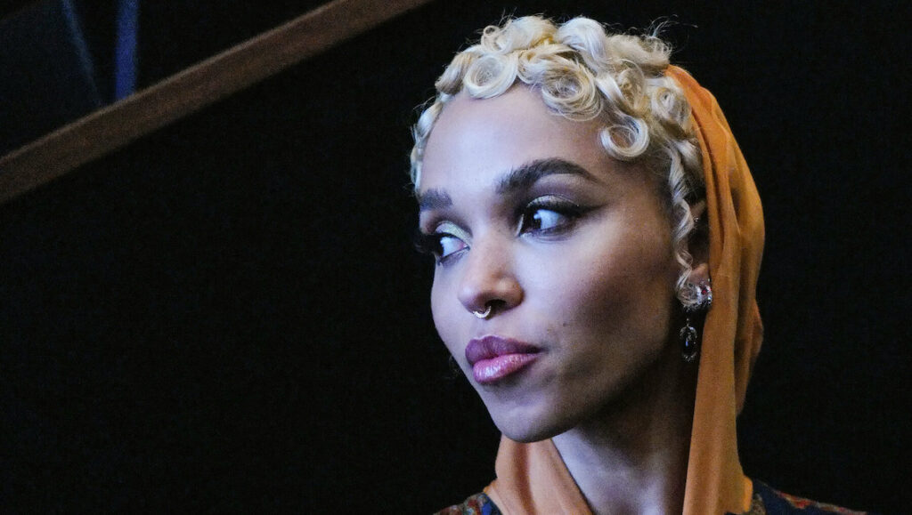 FKA Twigs — Caprisongs FKA Twigs portrait. Singer with blonde curly hair and orange headscarf. January 2022 album roundup.