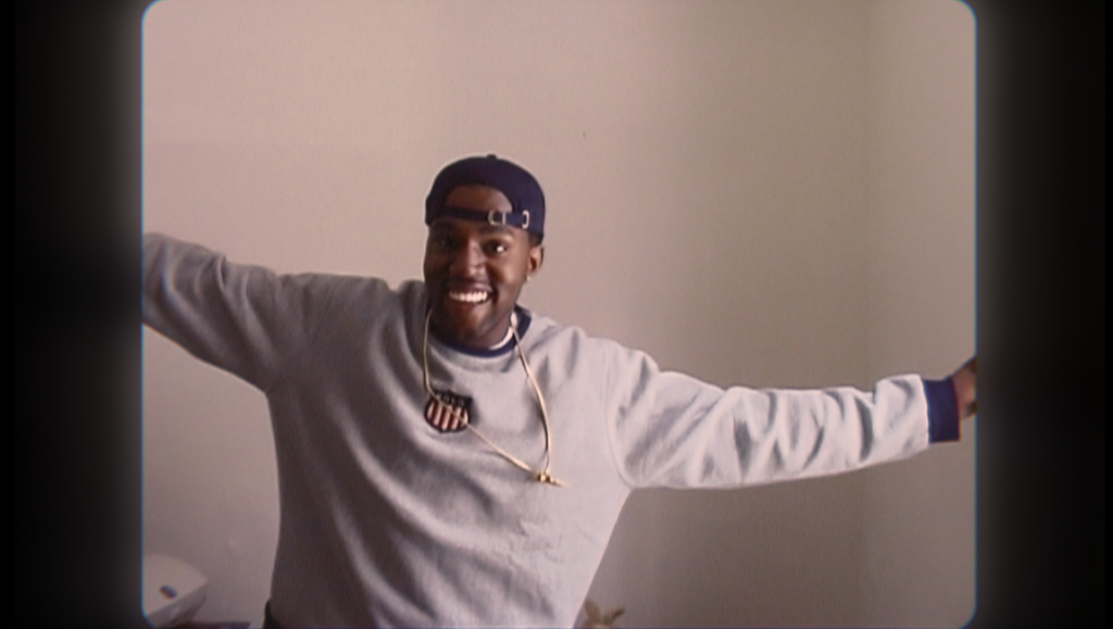 jeen-yuhs: A Kanye Trilogy — Coodie & Chike Kanye West in jeen-yuhs: A Kanye Trilogy. Smiling Kanye with a cap and necklace, arms outstretched. Documentary film scene.