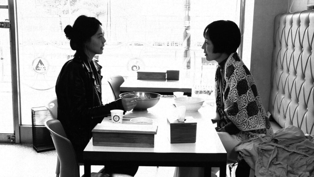 Berlin Film Festival 2022 — Dispatch 3: The Novelist’s Film, A Little Love Package, Terminal Norte A scene from The Novelist's Film at the Berlin Film Festival 2022. Two women converse at a table. Black and white.