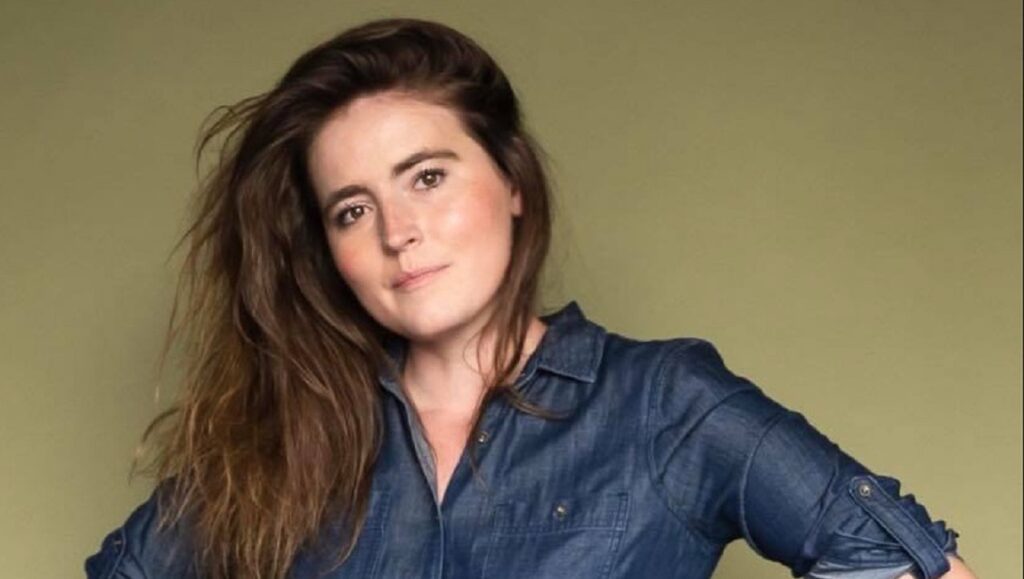 Rebeccah Love headshot. Calm and Chaos interview subject with long brown hair and denim shirt.