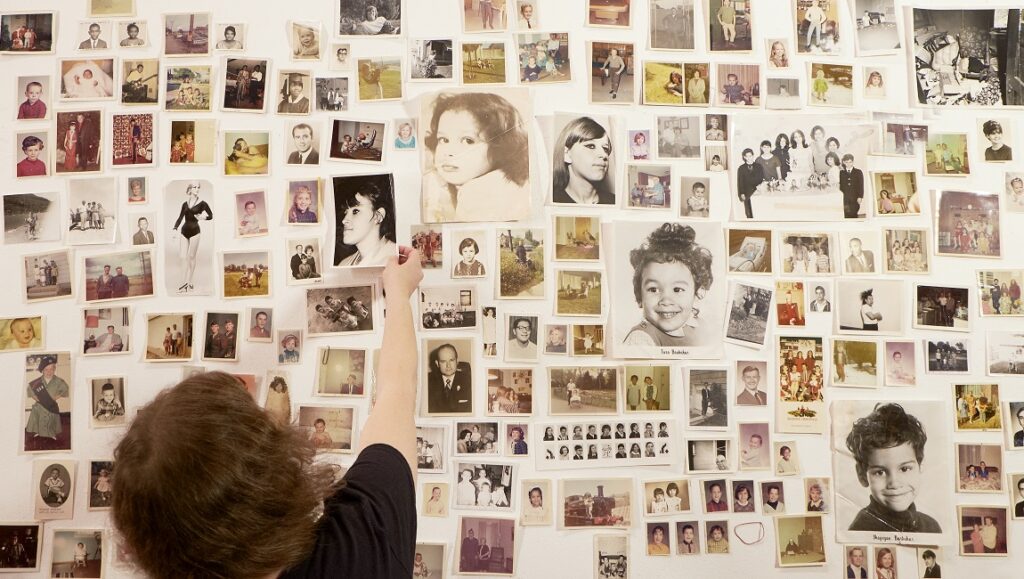 Dear Mr. Brody documentary still: A person arranging vintage photos on a wall.