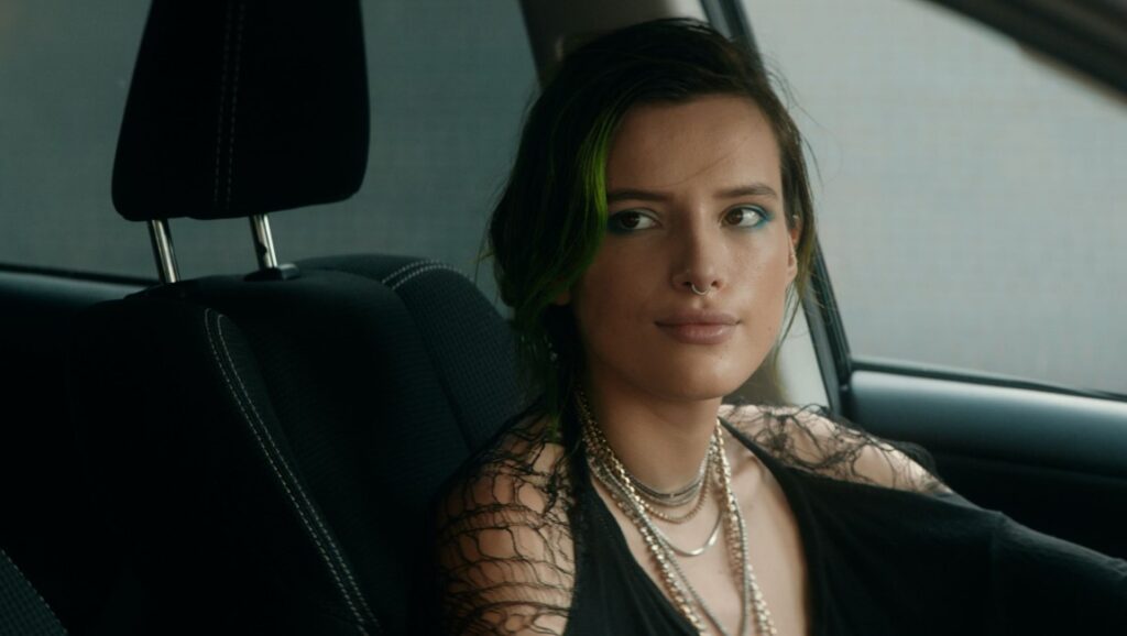 Bella Thorne in Measure of Revenge. Actress with green hair sits in a car. March 2022 movie releases.