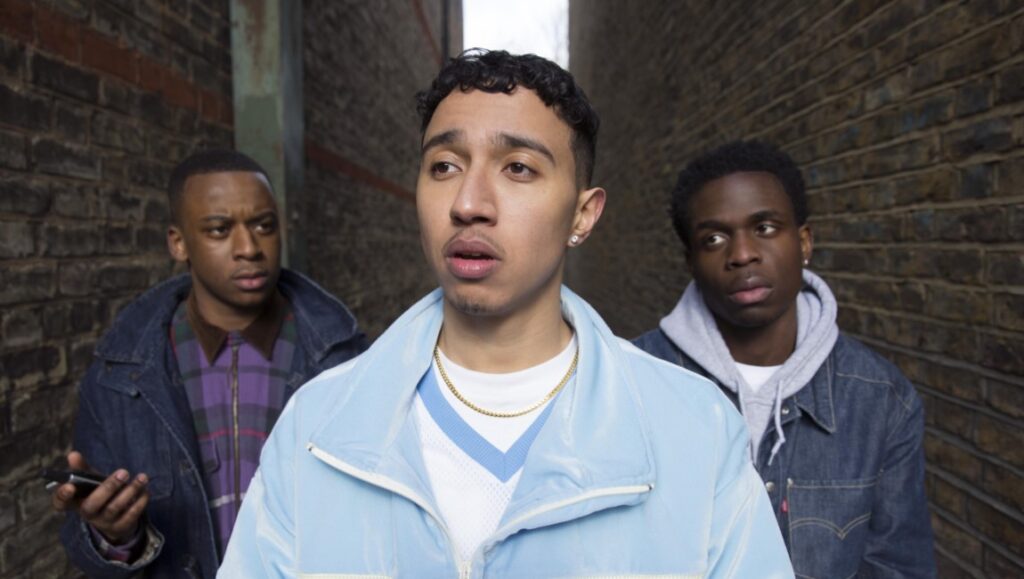 Three young men in an alleyway. Urban fashion, denim jackets. Friends, youth culture.
