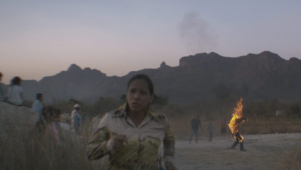 New Directors/New Films 2022: Dispatch 2 — Robe of Gems, Blue Island, Singing in the Wilderness Robe of Gems film scene: Woman running, person on fire, mountains. New Directors/New Films 2022.