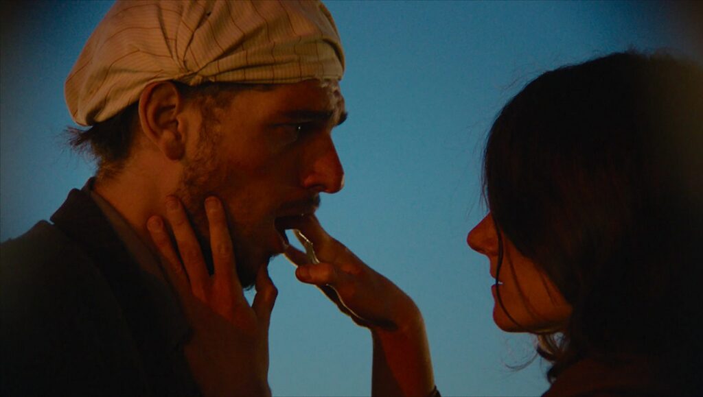 The City & the City — Syllas Tzoumerkas & Christos Passalis Pilgrims movie scene: man with headscarf and beard, woman's profile. Laurynas Bareisa film review.