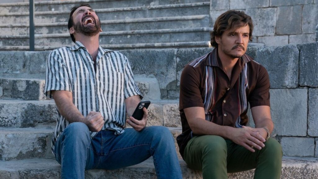 The Unbearable Weight of Massive Talent — Tom Gormican Nicolas Cage and Pedro Pascal in The Unbearable Weight of Massive Talent movie scene. Cage is laughing.