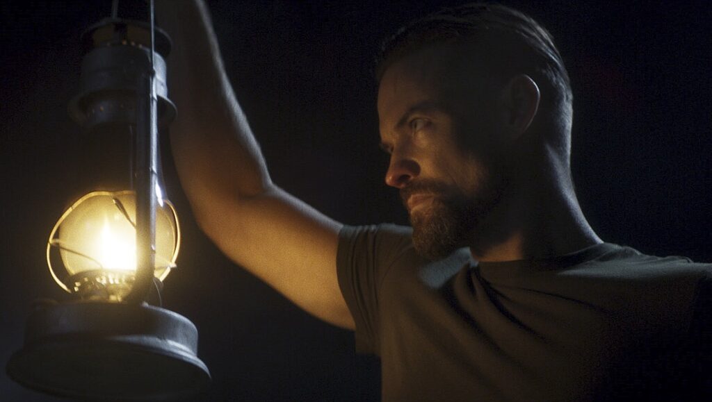 Escape the Field — Emerson Moore Man holding lantern at night. Before We Vanish May 2022: Cordelia, Mau, Mascarpone.