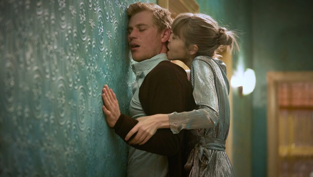 Cordelia, Mau in Before We Vanish (2022). Woman embraces man against patterned wall. Mascarpone film still.