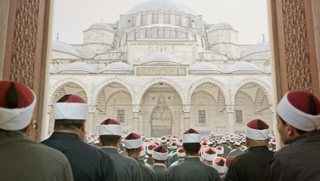Boy From Heaven — Tarik Saleh Boy From Heaven at Cannes Film Festival: Men in traditional hats facing a grand mosque.