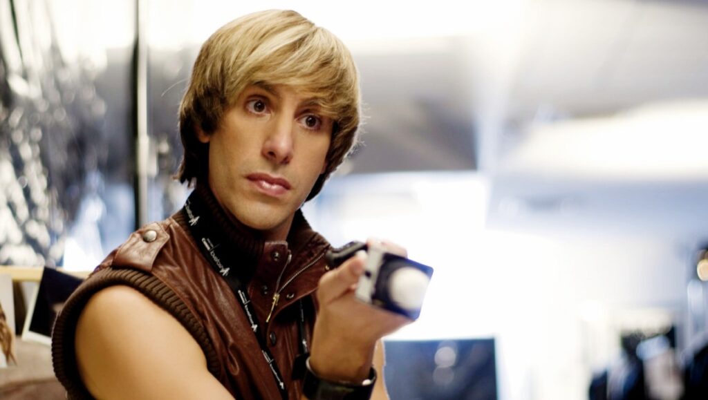 Sacha Baron Cohen as Brüno. Larry Charles film. Brown leather vest.