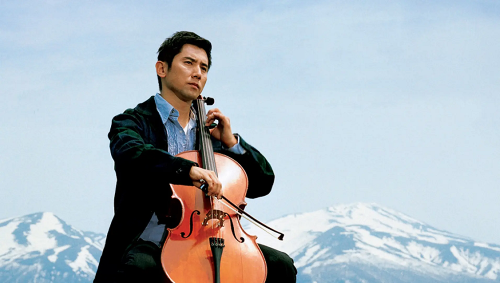 Masahiro Motoki plays cello in Departures, directed by Yōjirō Takita. Film scene with snowy mountains.