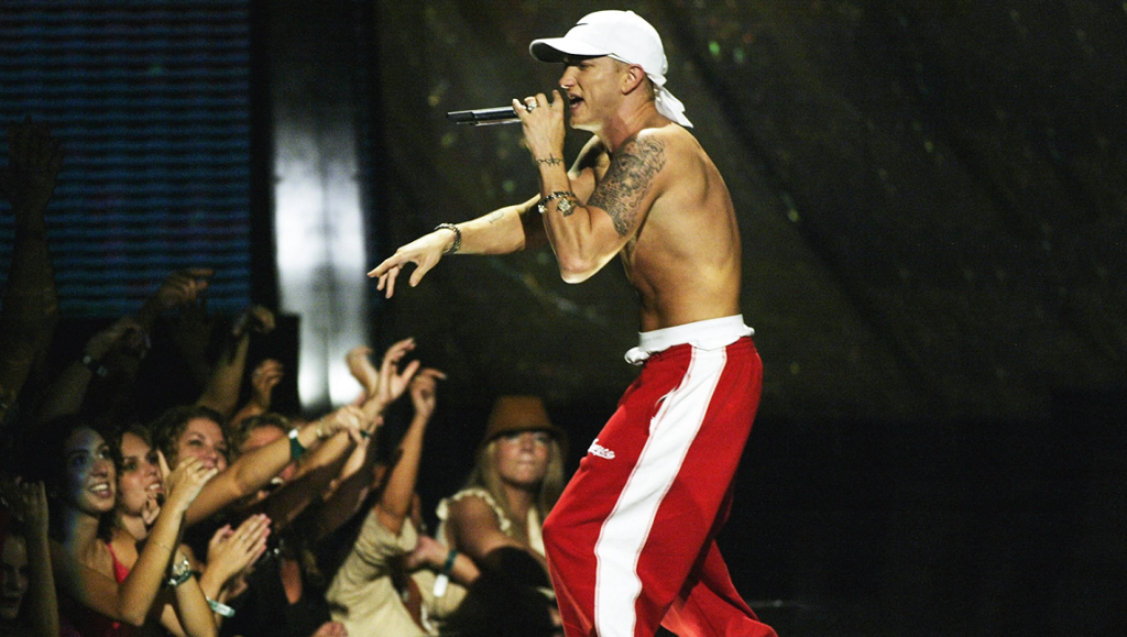 Eminem — The Eminem Show Eminem performing live during The Eminem Show era. Rapper with a mic in red pants.