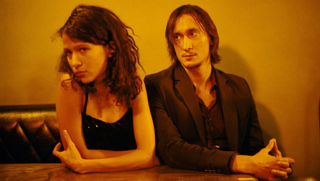 35 Shots of Rum — Claire Denis 35 Shots of Rum film still. Man and woman at a table, lit with warm, golden light. Claire Denis film.