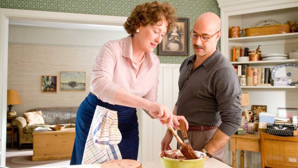Julie & Julia — Nora Ephron Meryl Streep and Stanley Tucci in Julie & Julia movie. Streep is cooking, Tucci watches. Nora Ephron film.
