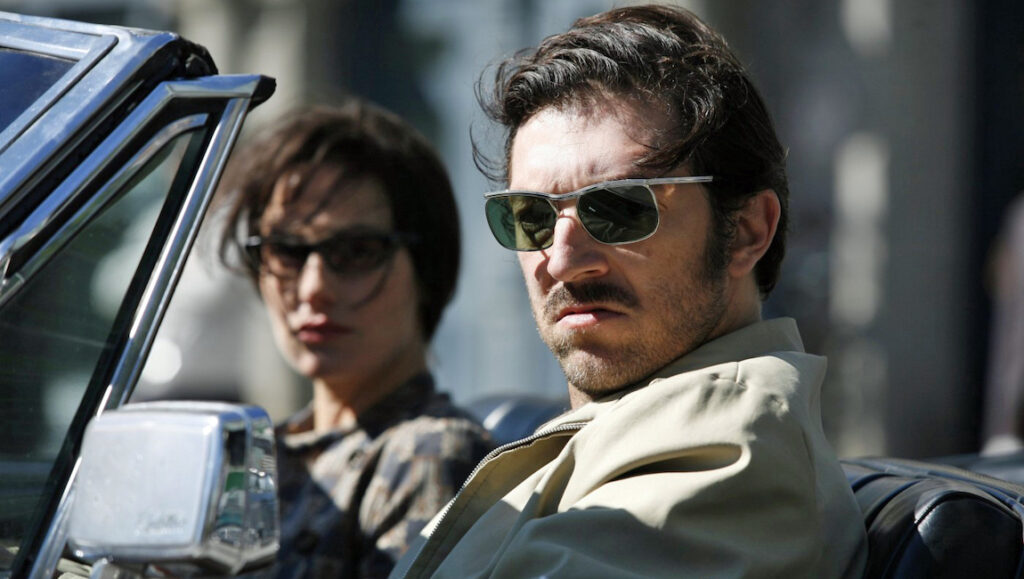 Mesrine — Jean-Francois Richet Man and woman in sunglasses in a car. Mesrine movie scene. Crime film.