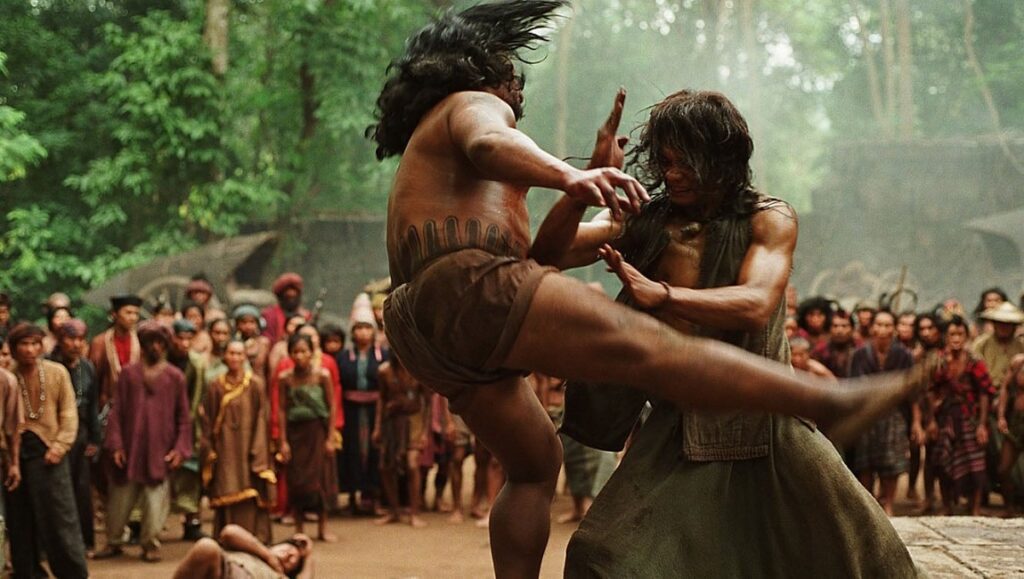 Ong Bak 2: The Beginning — Tony Jaa & Panna Rittikrai Tony Jaa in Ong Bak 2. Intense martial arts fight scene with crowd watching. Action movie.