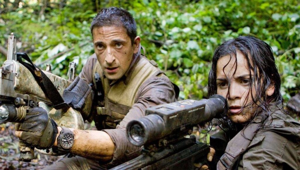 Predators — Nimrod Antal Actors Adrien Brody and Alice Braga in Predators movie. Armed characters in a jungle setting. Action film scene.