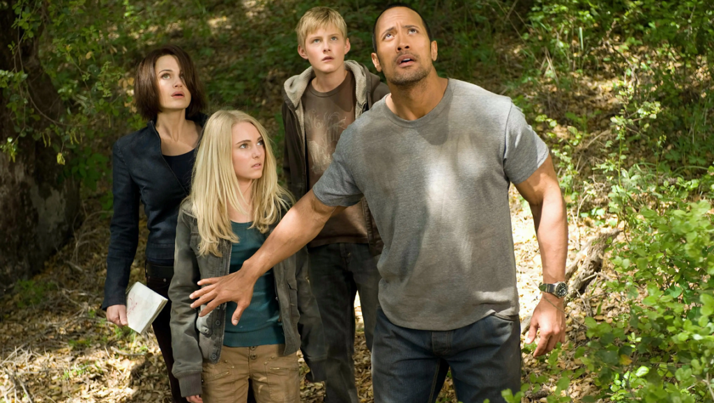 Race to Witch Mountain cast: Dwayne Johnson, AnnaSophia Robb, & Alexander Ludwig. Action scene in the woods.