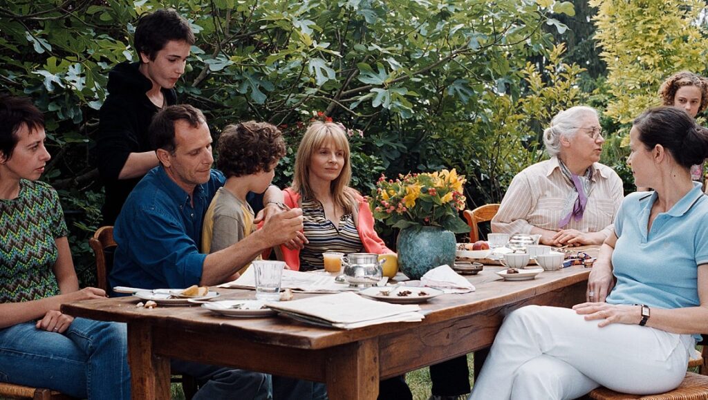 Summer Hours cast at outdoor table. Family scene from Olivier Assayas film. Cast includes Juliette Binoche.