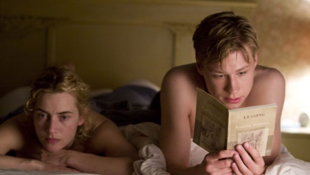 Kate Winslet and David Kross in The Reader movie. Kross reads a book in bed.