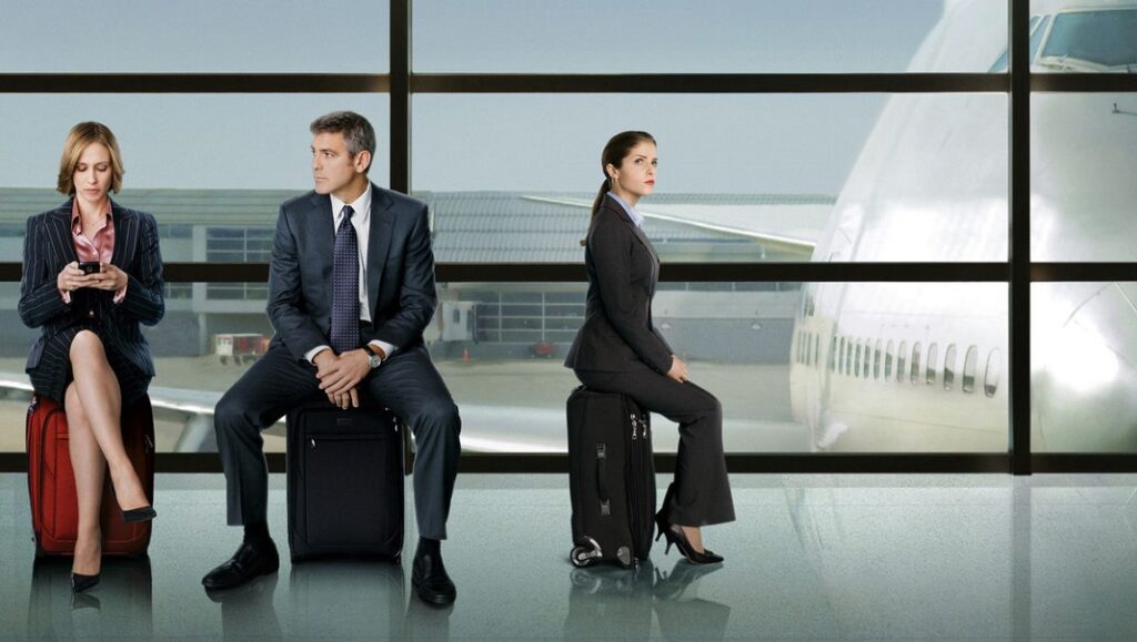 Up in the Air movie still. George Clooney, Anna Kendrick at airport. Business travel scene.