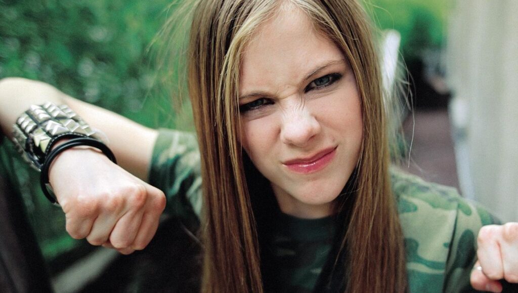 Avril Lavigne from Let Go era with studded bracelet and camo top.