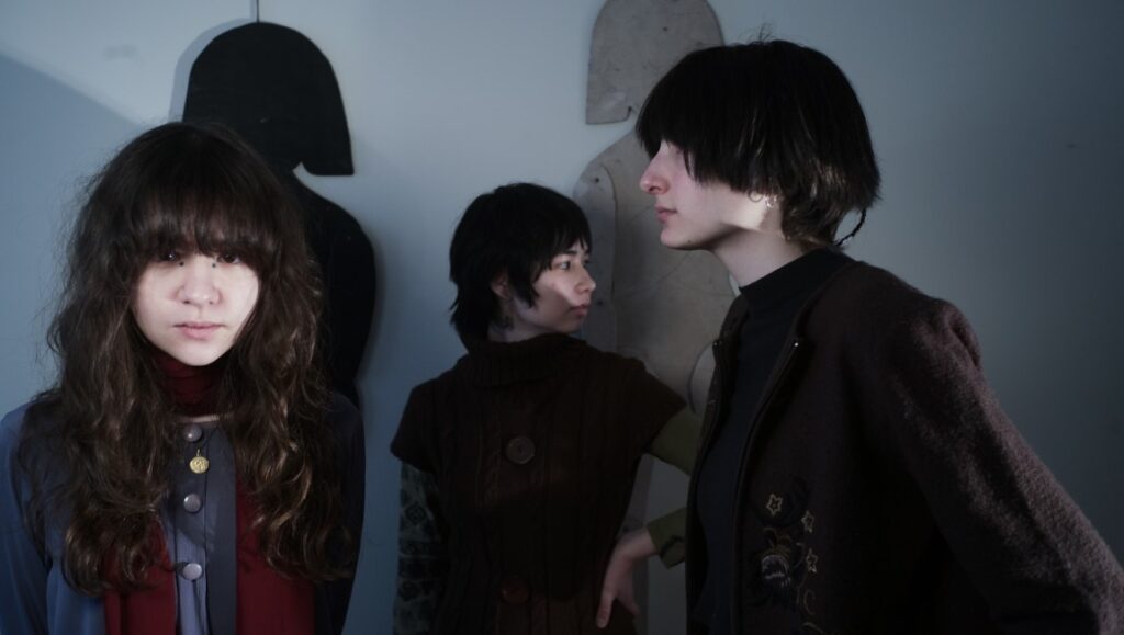 Horsegirl — Versions of Modern Performance Horsegirl band photo for June 2022 album roundup. Indie rock band members with dark hair pose in front of abstract shapes.