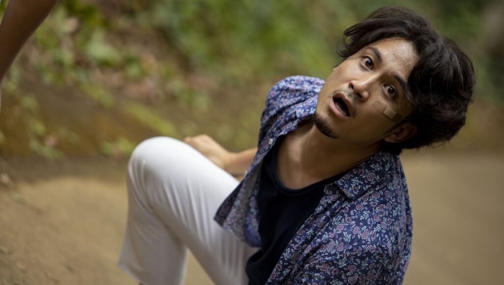 Actor in Popran at Fantasia Film Festival. Man with surprised expression, floral shirt, white pants. Indie film.