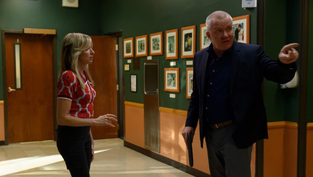 The Class — Nicholas Celozzi The Class movie scene. Woman and man in hallway with framed photos. September 2022 film review.