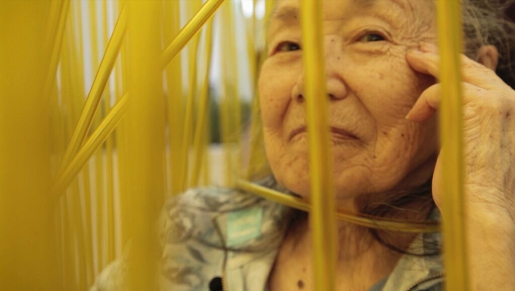 Wisdom Gone Wild at DOC NYC: Elderly woman behind yellow bars. Film review, documentary film festival.