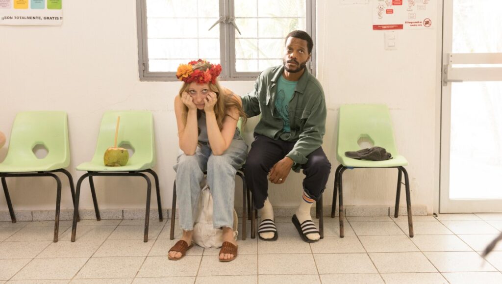 The Drop movie still: Anna Konkle and Jermaine Fowler sitting in a waiting room.