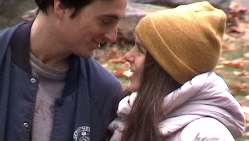 Yelling Fire in an Empty Theater — Justin Zuckerman Young couple in love. Woman in beanie and puffy jacket looks at man in bomber jacket. Romantic moment.