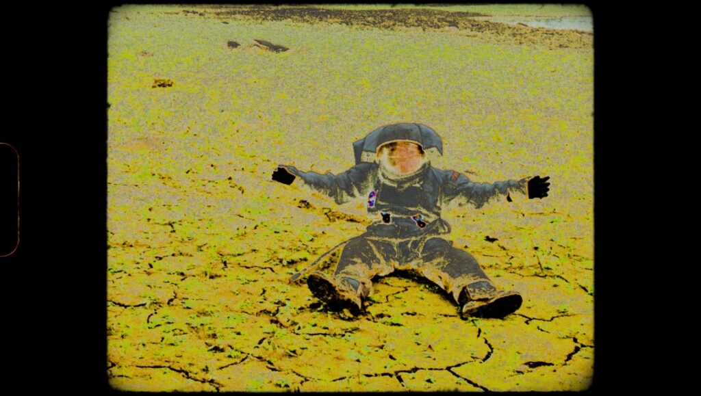 Notes From Eremocene film still: Astronaut lying on cracked, yellow earth. Viera Čákanyová's Berlinale '23 film review.