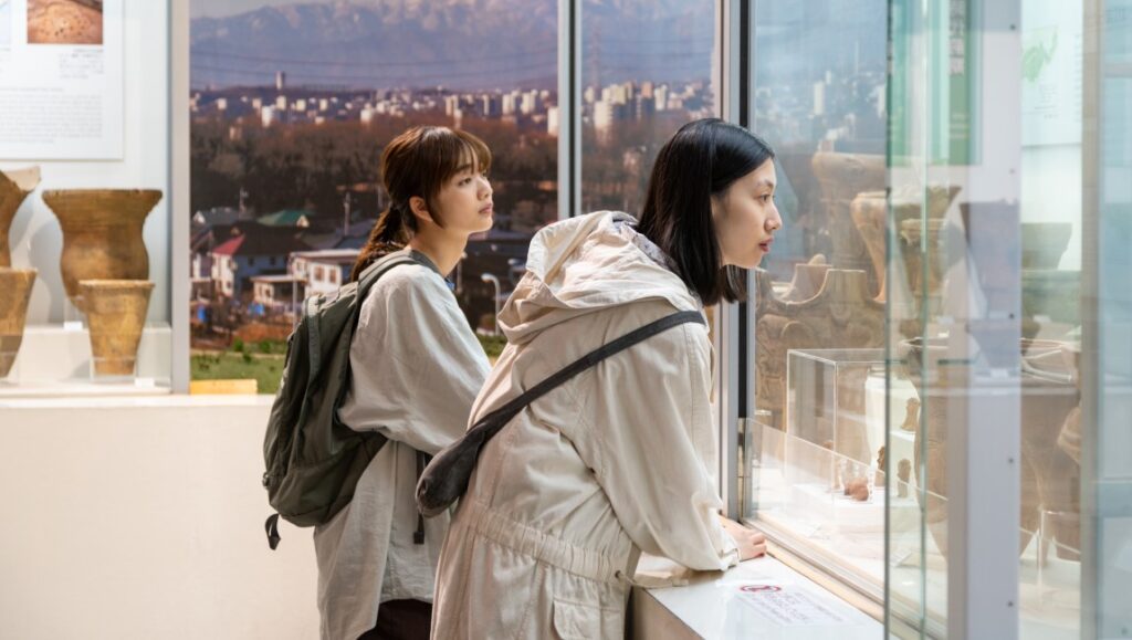 Remembering Every Night — Yui Kiyohara Remembering Every Night film at San Sebastián Film Festival. Two women view artifacts in a museum display case.