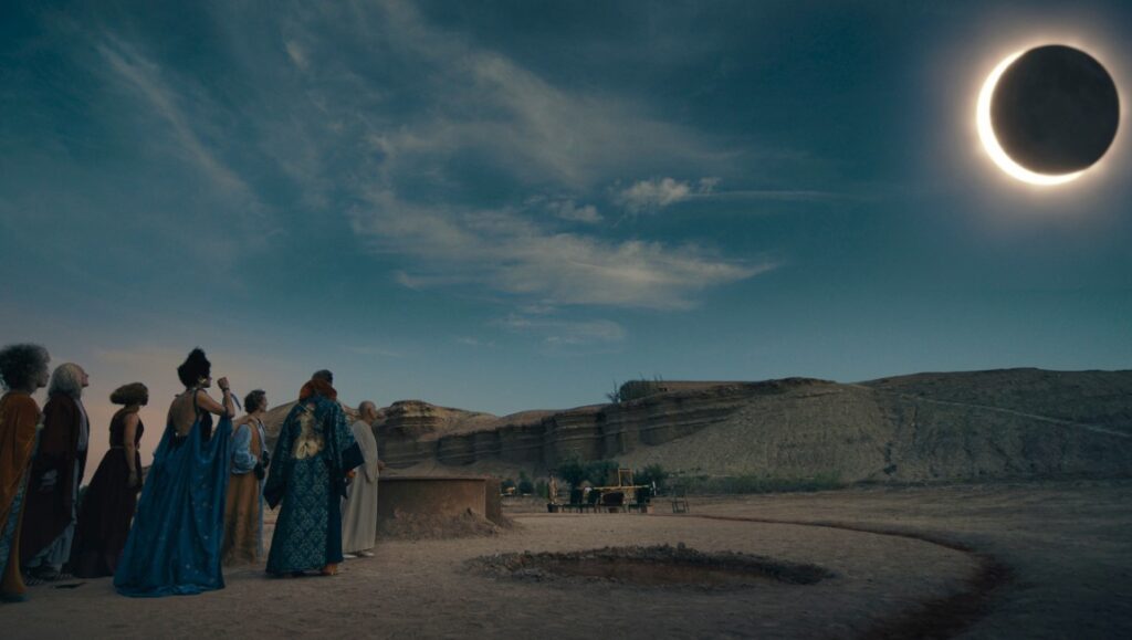 Solar eclipse scene. People gaze at the sky. Desert landscape with a total eclipse. Astronomy event.