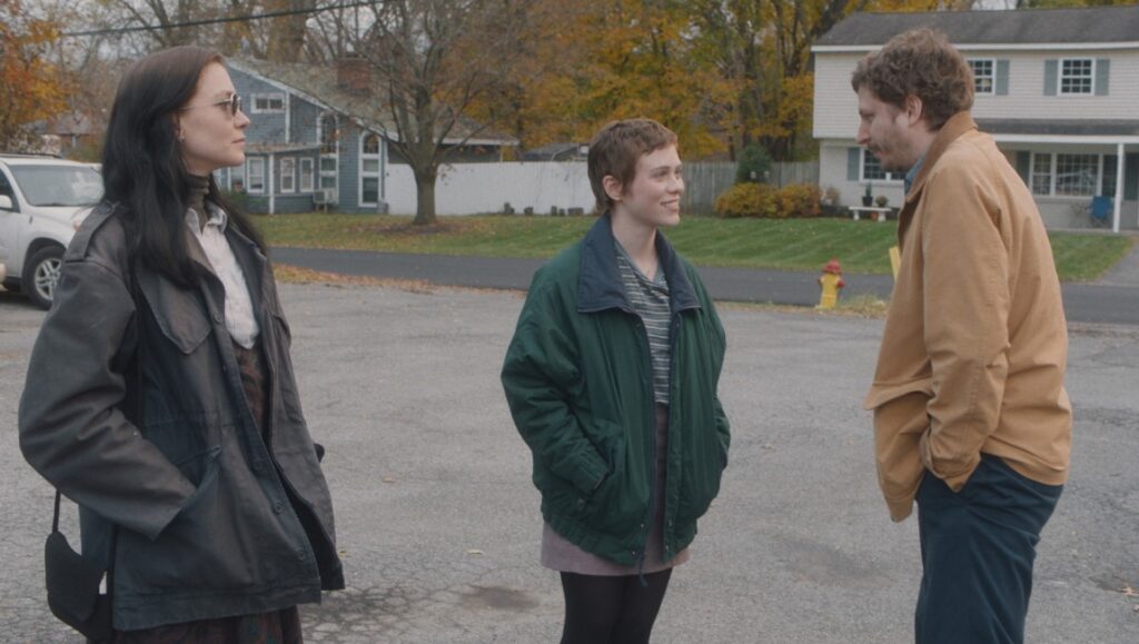 The Adults movie scene. Siblings Maggie, Nathan, and Eric in outerwear converse outdoors.