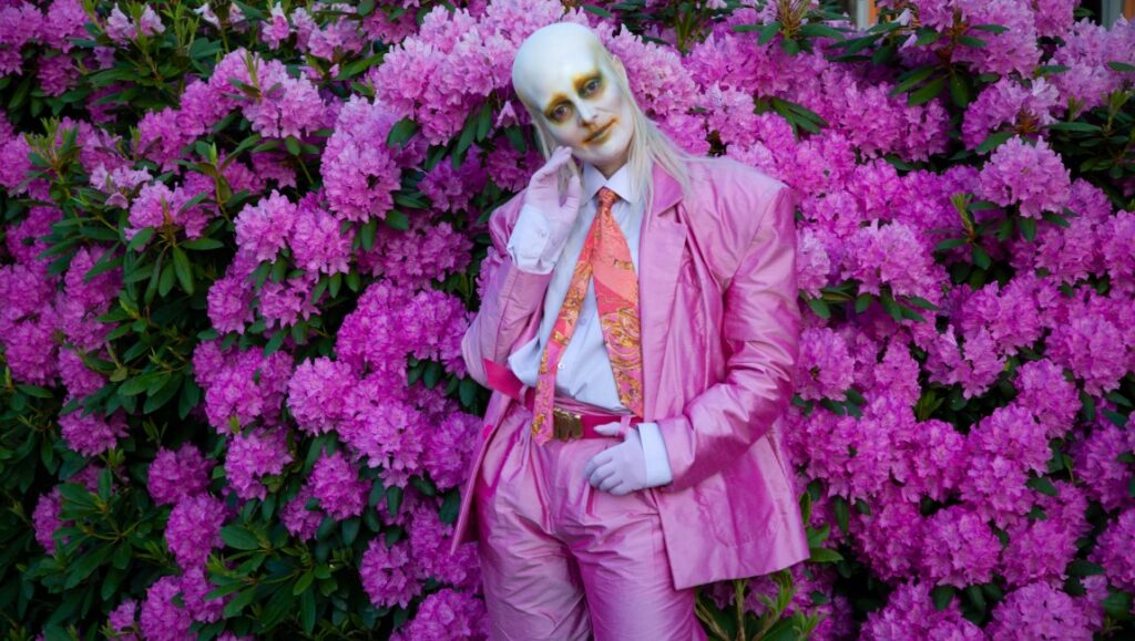 Fever Ray's Radical Romantics album art. Artist in pink suit with pink flowers.