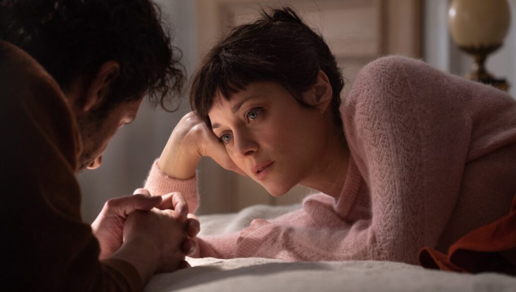 Marion Cotillard in Brother and Sister (2023). A woman looks at a man, holding his hands. Drama film.