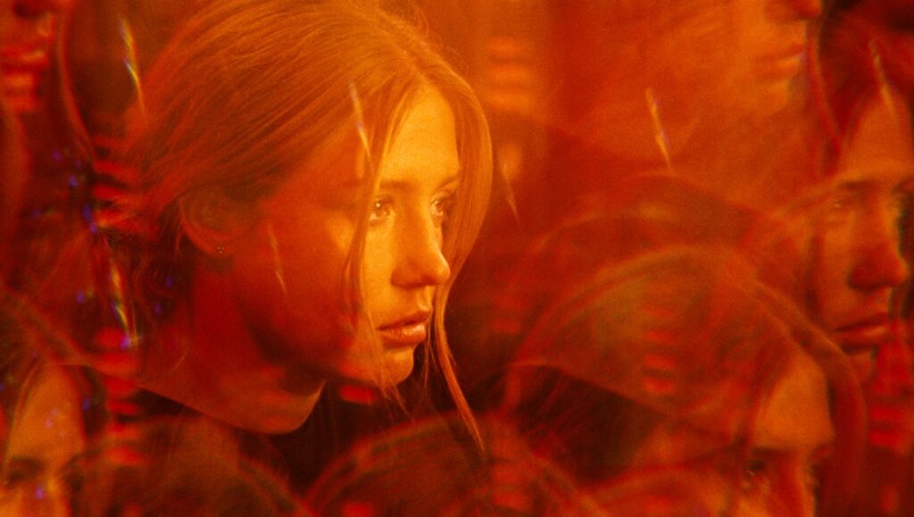 Nora Friese in The Five Devils movie. Léa Mysius film with orange, dreamlike visuals.