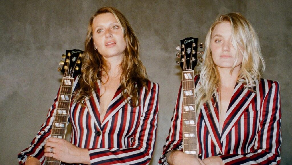 Aly & AJ — With Love From Aly & AJ pose with Gibson guitars. Sisters wear striped blazers. Musical duo, guitarists, musicians.