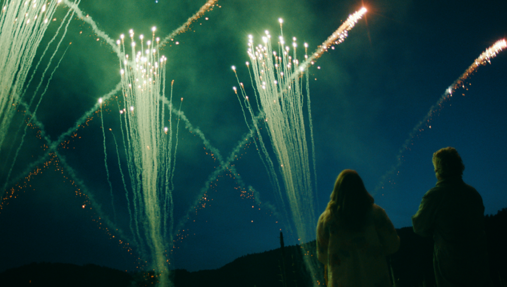 Acidman — Alex Lehmann Couple watching fireworks. Night scene with colorful pyrotechnics display. Outdoor celebration.