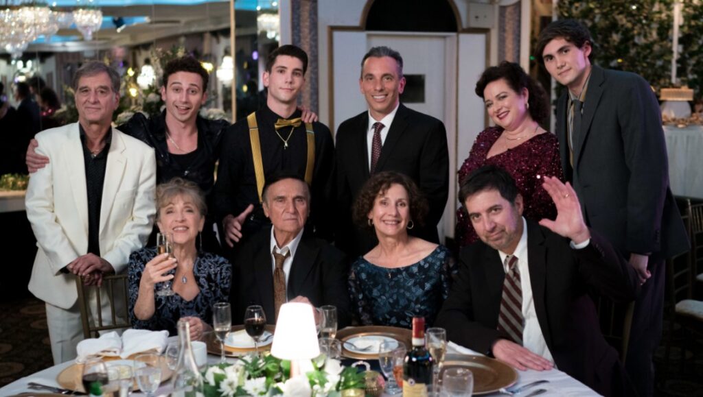 Cast of Somewhere in Queens movie at a celebratory dinner. Family gathering with actors at a formal event.