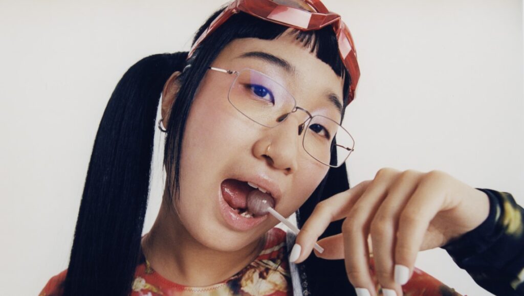 Yaeji — With A Hammer Yaeji portrait. Korean-American DJ with glasses, pigtails, and a lollipop. Dasom Han photography. Electronic music artist.
