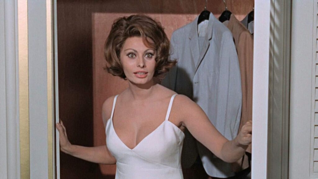 Sophia Loren in A Countess From Hong Kong. Loren wears a white dress in a closet. Classic film.
