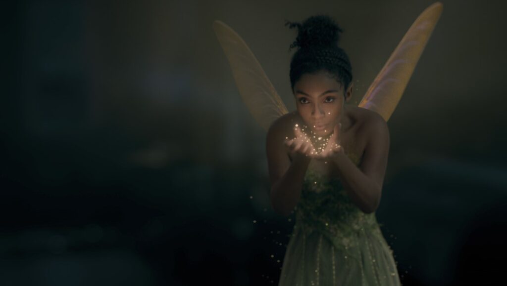 Yara Shahidi as Tinkerbell in Disney's Peter Pan and Wendy. Fairy dust sparkles in her hands.